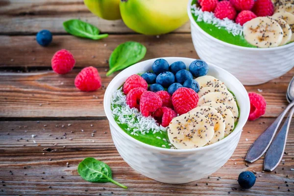 健康早餐碗︰ 香蕉、 蓝莓、 覆盆子、 正大种子和椰子绿色菠菜思慕雪 — 图库照片