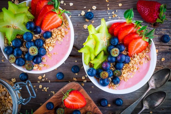 Healthy breakfast bowl: raspberry smoothies with granola, blueberries, strawberries and carambola — Stock Photo, Image