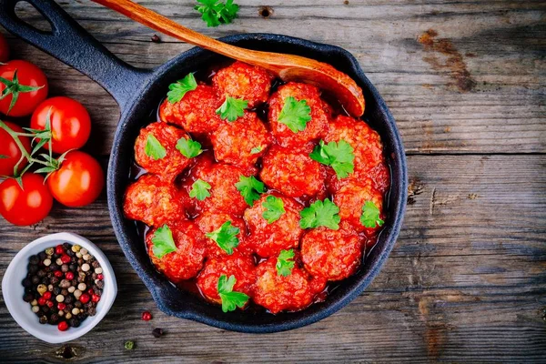 Boulettes de viande avec sauce tomate et persil dans une casserole en fonte — Photo