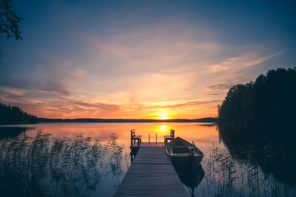 Nascer do sol sobre o cais de pesca no lago na Finlândia — Fotografia de Stock