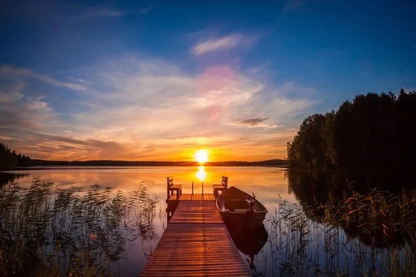 Pôr do sol sobre o cais de pesca no lago na Finlândia — Fotografia de Stock