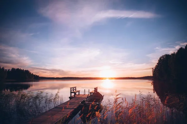 Salida del sol sobre el muelle de pesca en el lago de Finlandia — Foto de Stock