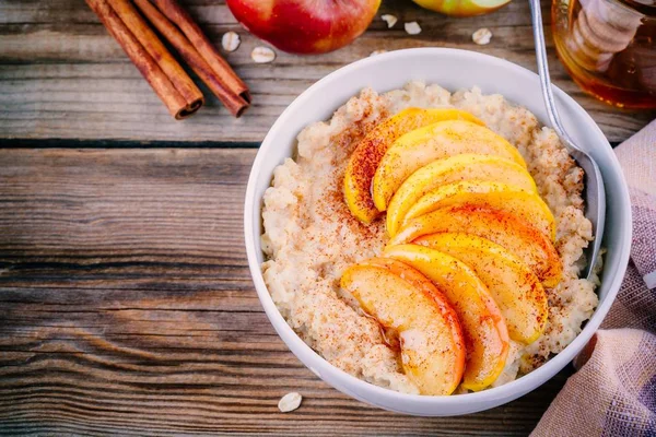 Desayuno saludable: tazón de avena con manzanas caramelizadas, canela y miel — Foto de Stock