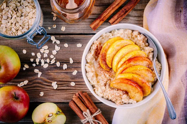 健康的早餐︰ 燕麦粥碗与焦糖的苹果、 肉桂粉和蜂蜜 — 图库照片
