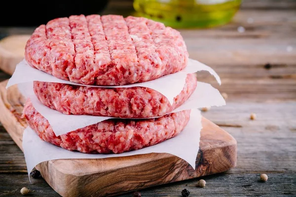 Ingredients for burgers: raw minced beef cutlets — Stock Photo, Image