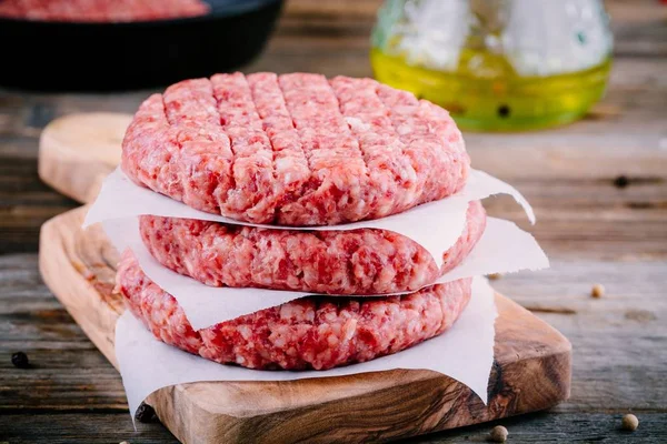 Ingredients for burgers: raw minced beef cutlets — Stock Photo, Image