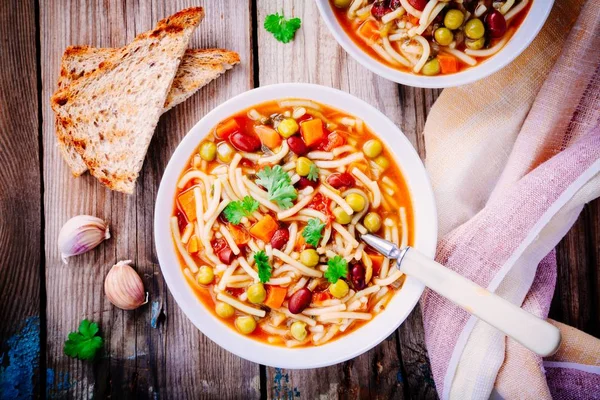 Суп из минестроне с овощами и макаронами и тостами из цельного зерна — стоковое фото