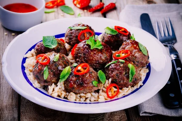 Hemlagade köttbullar med vildris, mynta, grön lök och chili sås — Stockfoto