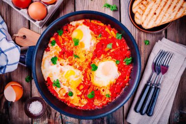 Shakshuka. Kızarmış yumurta domates, kırmızı biber ve maydanoz ile