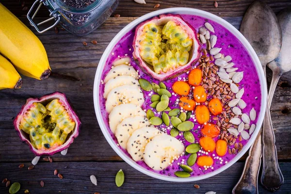 Tazón de batidos de arándanos con espino cerval de mar, plátano, fruta de la pasión, semillas de chía, semillas de calabaza, girasol y semillas de lino — Foto de Stock