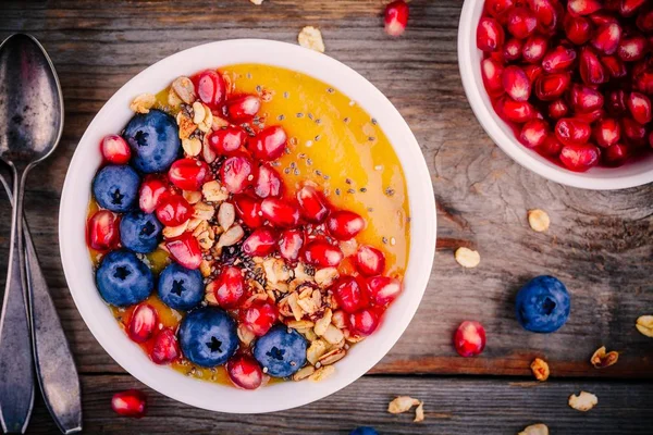 Saudável tigela de smoothie de manga de verão com granola, mirtilos, romã e sementes de chia — Fotografia de Stock