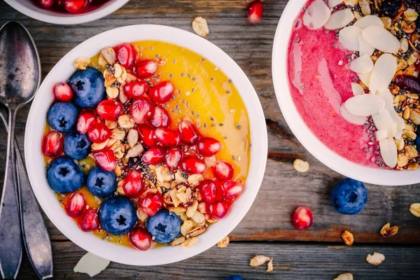 夏日健康早餐芒果和覆盆子奶昔碗用格兰诺拉麦片、 蓝莓、 石榴和正大种子 — 图库照片