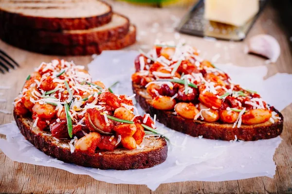 Bruschetta com feijão assado em molho de tomate com alecrim — Fotografia de Stock