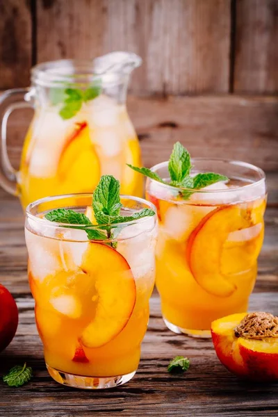 Bebidas frias de verão: sangria de pêssego caseira com cubos de gelo e hortelã em óculos — Fotografia de Stock