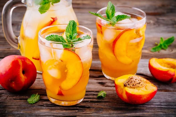 Summer cold drinks: homemade peach sangria with ice cubes, and mint in glasses — Stock Photo, Image