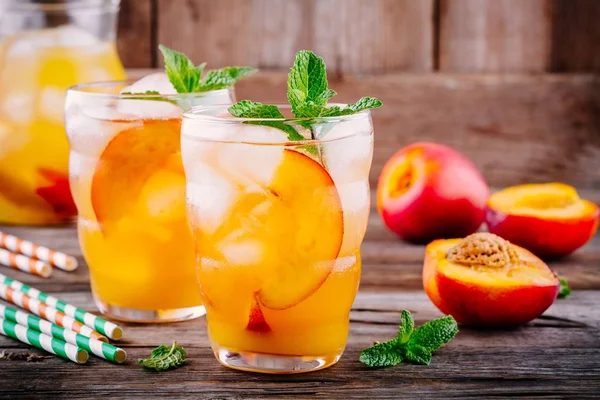 Sommaren kalla drycker: Hemmagjord persiko saft med isbitar och mynta i glas — Stockfoto