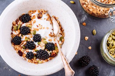 Sağlıklı kahvaltı kase yoğurt granola, keten tohumu, kabak çekirdeği ve taze böğürtlen ile