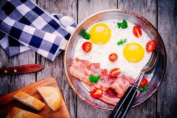 Сніданок зі смаженими яйцями, беконом, помідорами та петрушкою — стокове фото