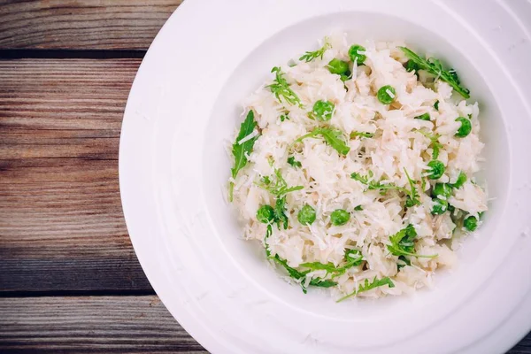 Hemmagjord risotto med kyckling, gröna ärtor, rucola och parmesan — Stockfoto