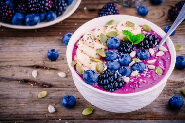 Taze böğürtlen, yaban mersini, muz, ayçiçeği çekirdeği, kabak çekirdeği, chia tohum ve Hindistan cevizi ile güler yüzlü kase