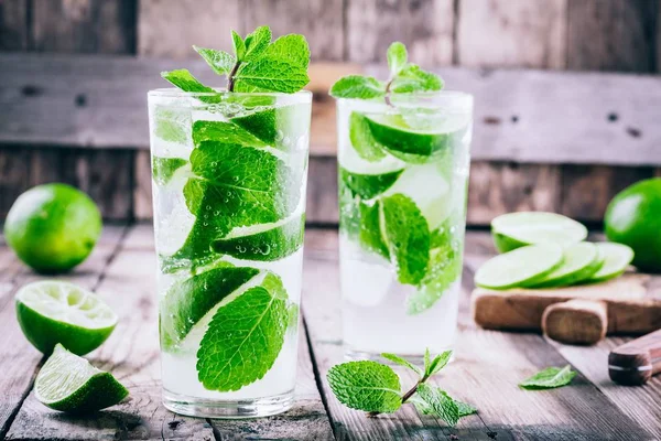 Cócteles mojitos frescos con lima, menta y hielo en vaso —  Fotos de Stock