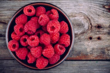 Taze olgun organik ahududu ahşap arka plan üzerinde bir tabak içinde