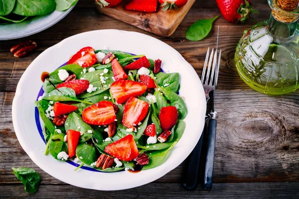 Spinach salad with strawberries, goat cheese, balsamic and walnuts — Stock Photo, Image