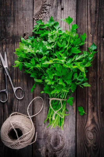 Bunch of fresh organic parsley on a wooden rustic background. — Stock Photo, Image
