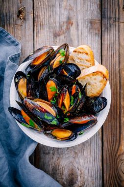 Sos ve maydanozlu lezzetli deniz ürünleri midyeleri. Limon ve baget. Deniz kabuklarında istiridye.  