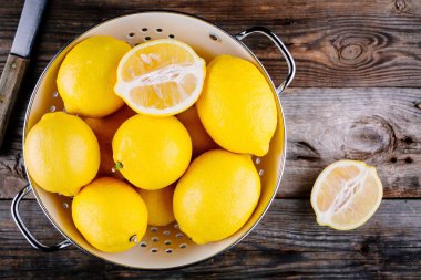 ahşap arka plan üzerinde bir kevgir içinde taze organik limon. Üstten Görünüm