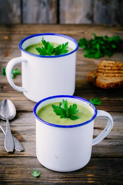 Hemmagjord grön zucchini grädde soppa med persilja i muggar — Stockfoto