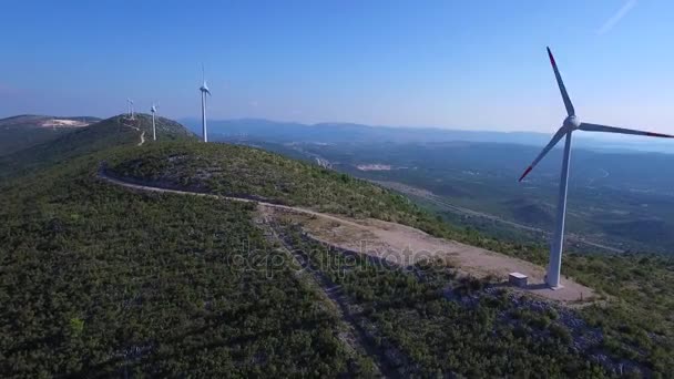 Güneşli bir deniz kenarında dağın zirvesine de rüzgar türbinleri — Stok video