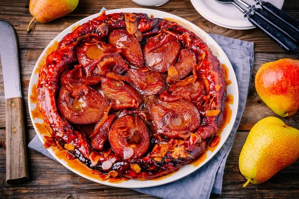 Tarte tatin karamelize armut, portakal kabuğu ve badem ile