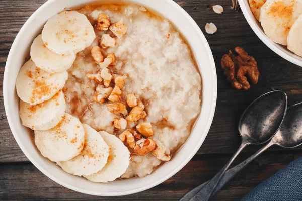 Saludable tazón de desayuno. harina de avena con plátano, nueces, semillas de chía y miel — Foto de Stock