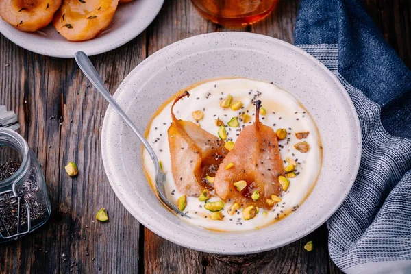 Gesunde Frühstücksschale: Joghurt mit karamellisierten Birnen, Pistazien, Honig und Chiasamen — Stockfoto