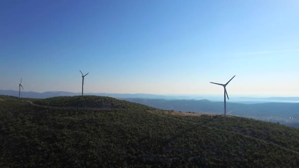 Wind turbines at the top of the mountain by the sea on a sunny day, aerial video, Croatia. — Stock Video