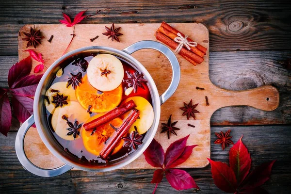 Hot mulled cider drink with citrus, apples, cinnamon sticks, cloves and anise in cooking pan — Stock Photo, Image