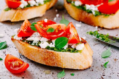 Bruschetta pesto sosu, beyaz peynir, domates ve fesleğen ile