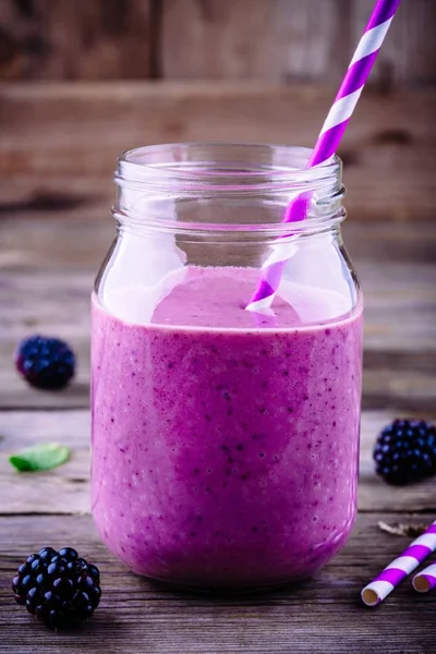 ahşap rustik arka plan üzerinde bir mason kavanoza BlackBerry güler yüzlü