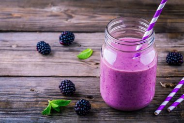 ahşap rustik arka plan üzerinde bir mason kavanoza BlackBerry güler yüzlü