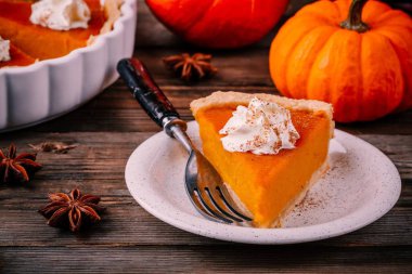 Krem şanti ve ahşap zemin üzerine tarçın ile Şükran günü için ev yapımı Pumpkin Pie