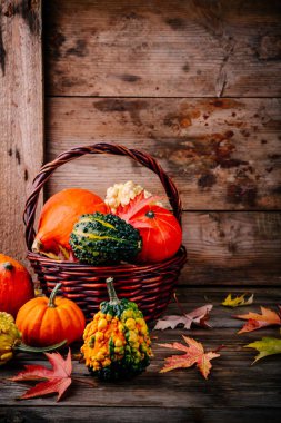 Renkli kabaklar ve ahşap arka plan üzerinde sonbahar yaprakları