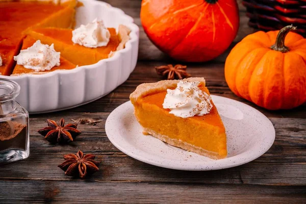 Hemmagjord Pumpkin Pie för Thanksgiving med vispgrädde och kanel på trä bakgrund — Stockfoto