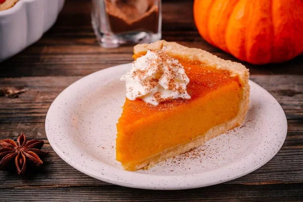 Hemmagjord Pumpkin Pie för Thanksgiving med vispgrädde och kanel på trä bakgrund — Stockfoto