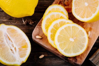 Ahşap arka plan üzerinde olgunlaşmış taze limon dilimleri