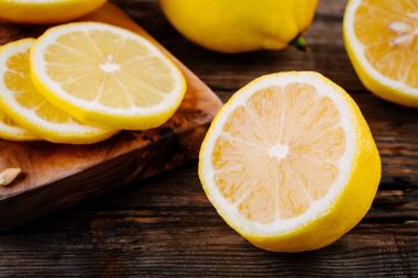 Ahşap arka plan üzerinde olgunlaşmış taze limon dilimleri