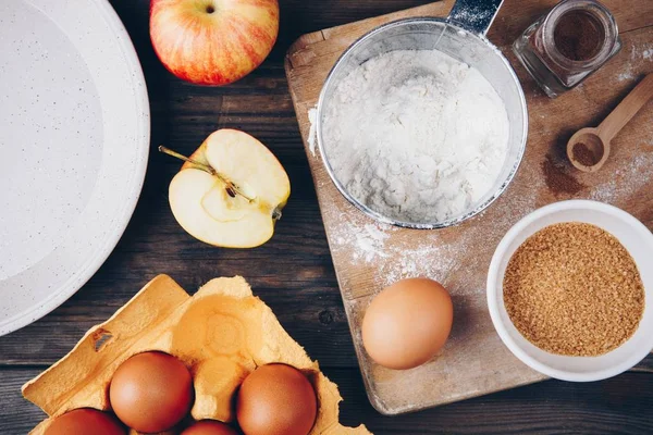 Elmalı turta taze kırmızı elma, un, yumurta, kahverengi şeker ve baharat ile yemek pişirmek için malzemeler 