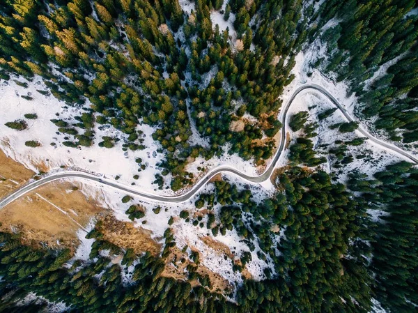 Αεροφωτογραφία του χιονισμένου δάσους με δρόμο. Αιχμαλωτίστηκε από ψηλά με τηλεκατευθυνόμενο — Φωτογραφία Αρχείου