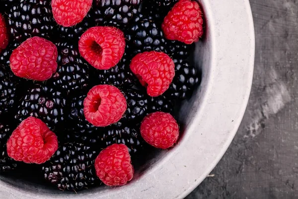 Fresh ripe organic raspberries and blackberries in a bowl closeup — Stock Photo, Image