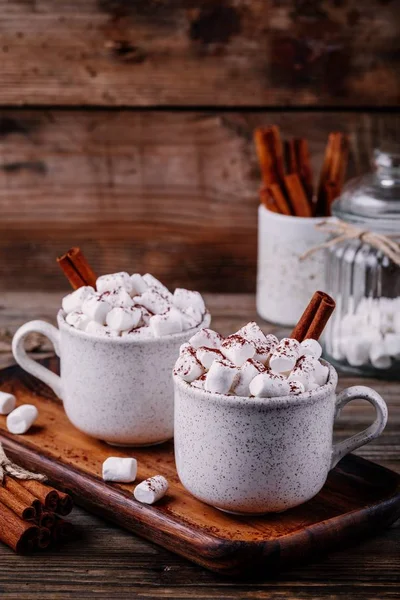 Bebida de Natal. Chocolate quente com marshmallows e canela no fundo de madeira escura . — Fotografia de Stock